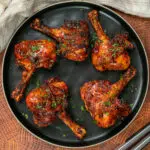 smoked bbq chicken legs on a plate butterflied