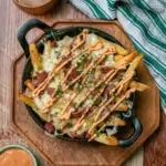 loaded reuben fries in a cast iron skillet with Russian dressing
