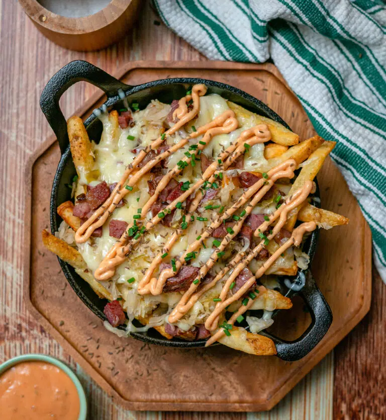 loaded reuben fries in a cast iron skillet with Russian dressing