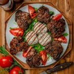 overhead shot of balsamic glazed lamb chops with tomato and cheese
