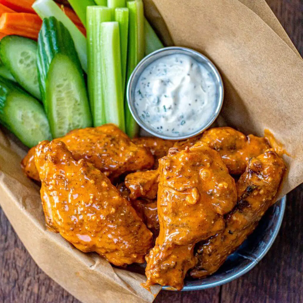 wings in a basket with celery and bleu cheese dressing