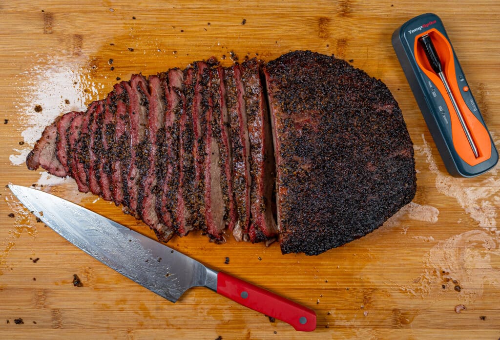 smoked beef brisket flat with a sharp knife and a temp spike thermometer