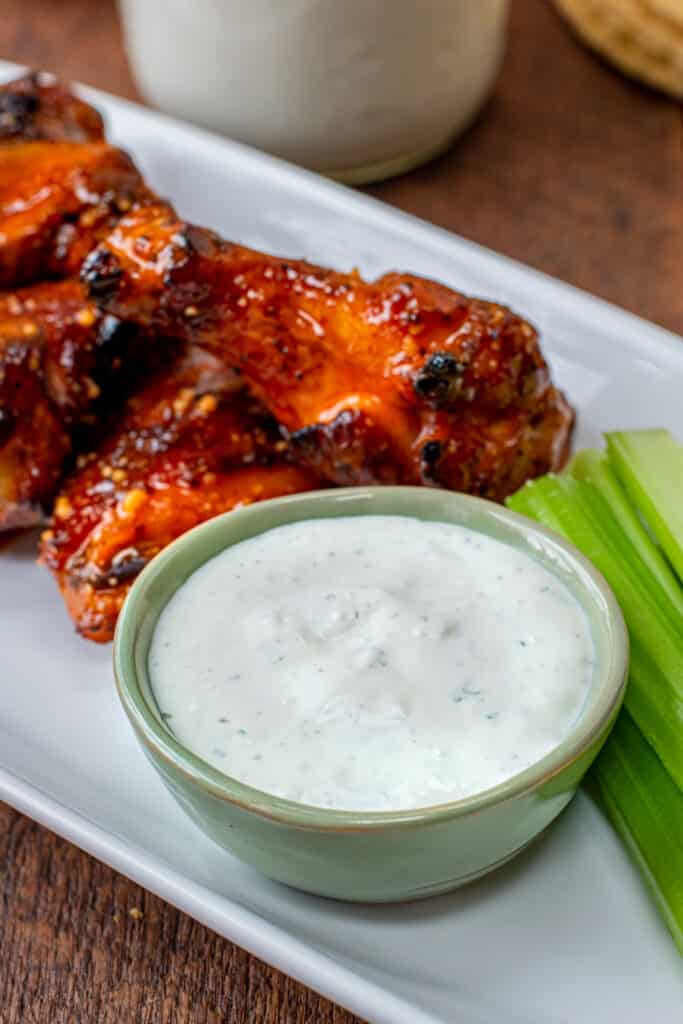 cup of blue cheese dressing with wings