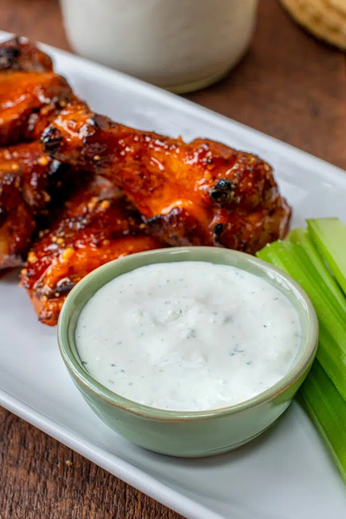 cup of blue cheese dressing with wings