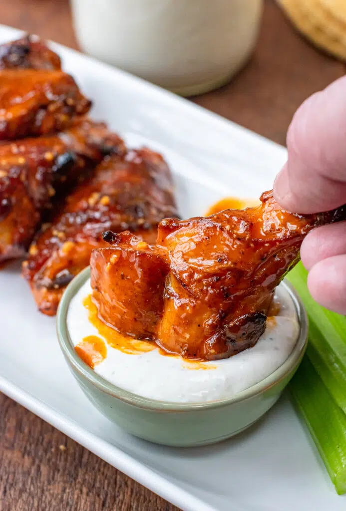 dipping chicken wing in blue cheese dressing