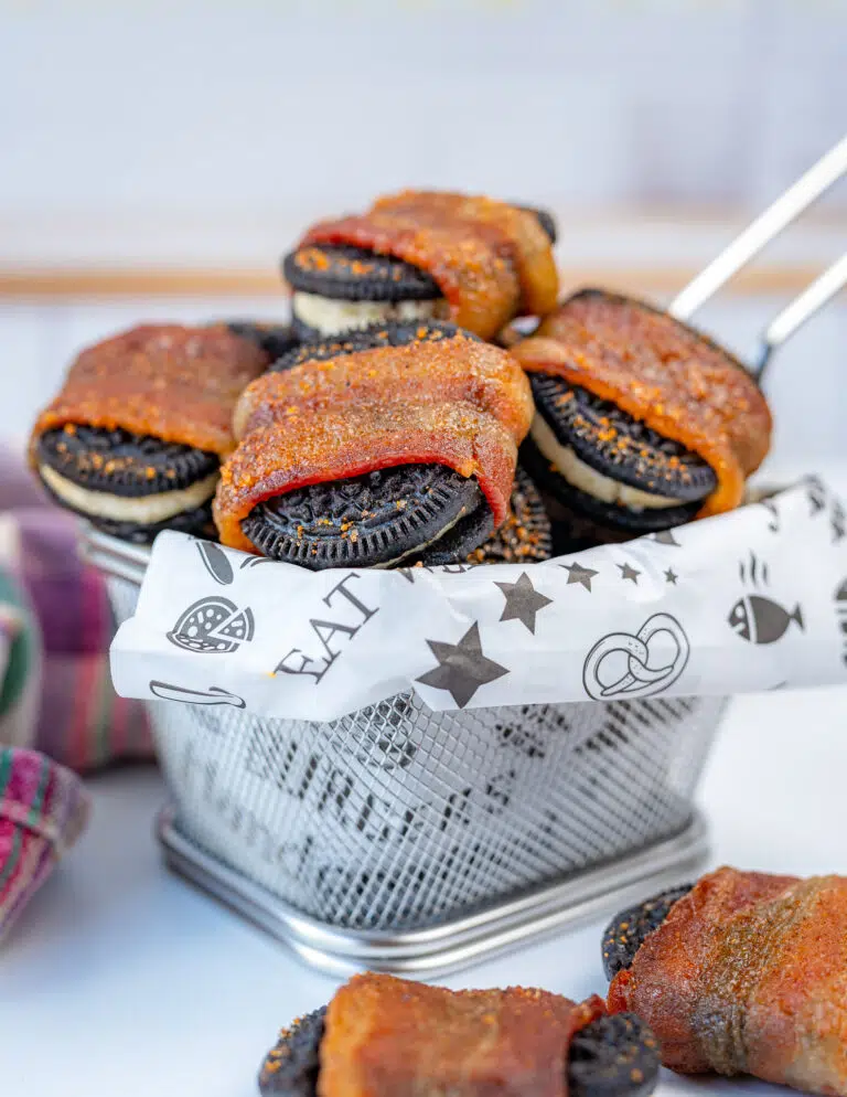 bacon wrapped Oreos in a basket with white deli paper
