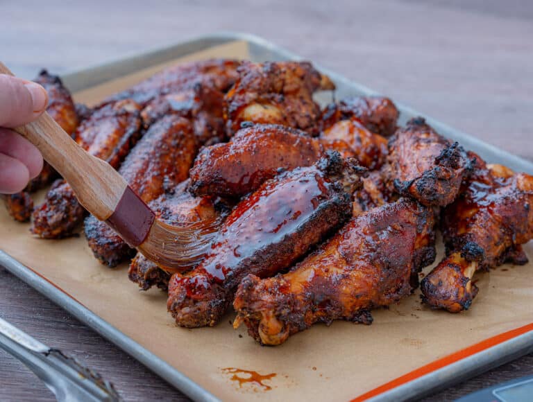 brushing bbq sauce on smoked turkey wings