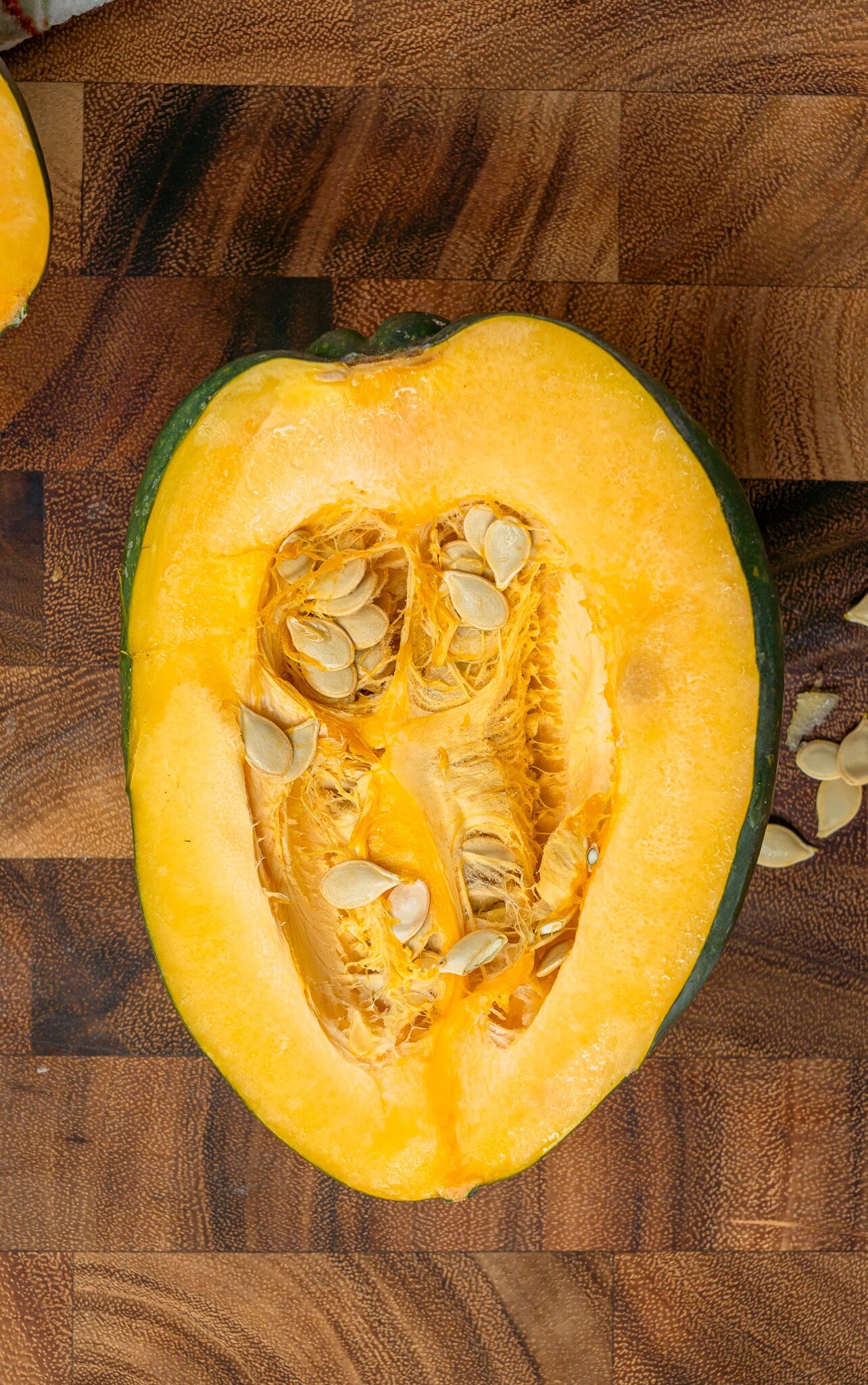 raw acorn squash cut in half with seeds in it
