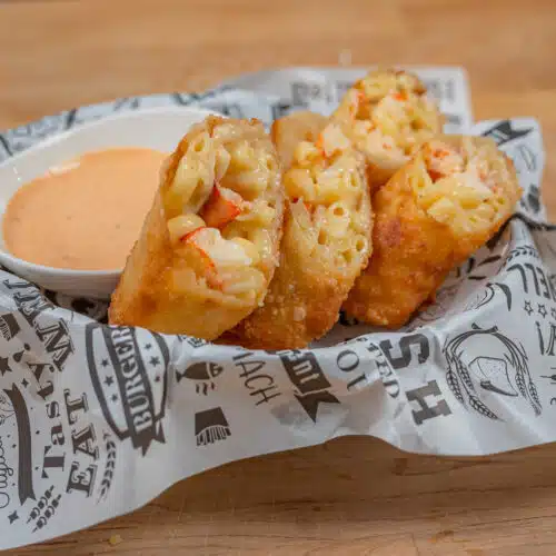 Lobster Egg Roll in a basket with dipping sauce