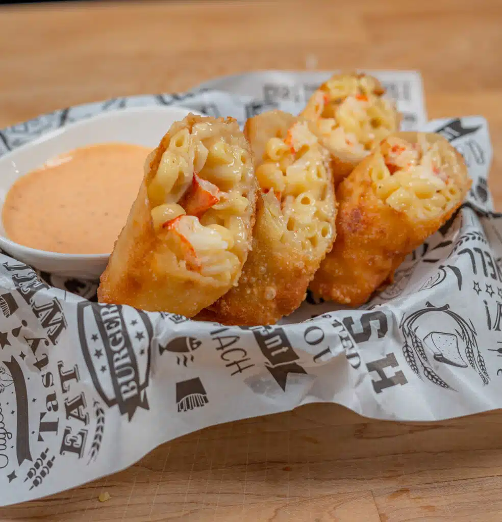Lobster Egg Roll in a basket with dipping sauce