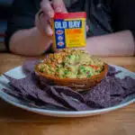 Crab guacamole in a bowl with blue corn tortillas