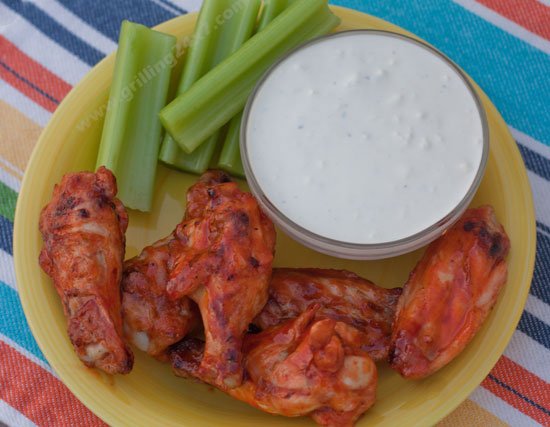 yellow plate with Sriracha and Honey wings, celery and dipping sauce