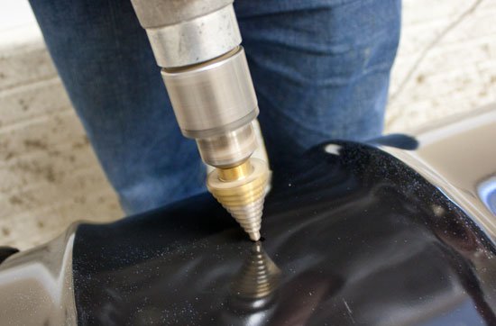 drilling into the side of a steel drum for a UDS