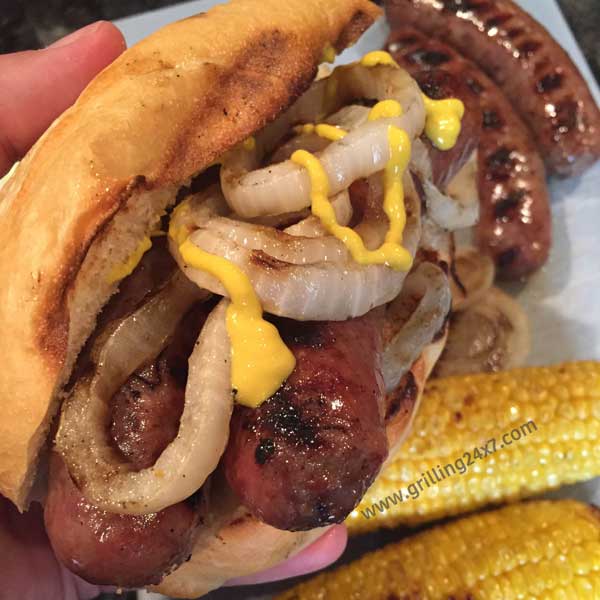 Double beer brat sub with grilled onions, grilled corn on a toasted bun - Grilling24x7.com
